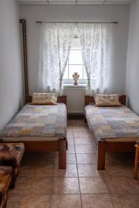 two beds in a room with a window at Apartment Sučany 3 in Sučany