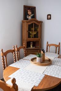 a dining room with a wooden table with chairs and a cabinet at Apartment Sučany 3 in Sučany +15 photos