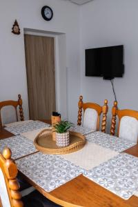 a dining room table with two chairs and a tv at Apartment Sučany 3 in Sučany