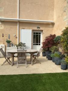 a patio with a table and chairs and plants at La Maison de Marie in Blaye