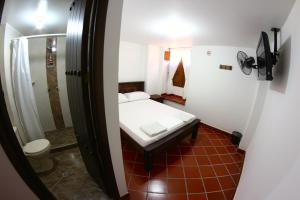a small bedroom with a bed and a shower at Posada Bacaregua in San Gil