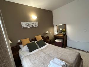 a bedroom with a bed and a table and a mirror at Edelweiss Mountain Apartment - Stream Resort Spa & Pool, Pamporovo in Pamporovo +28 photos