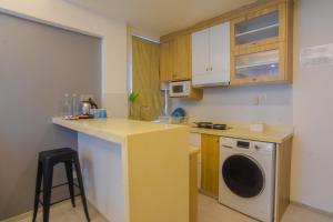 a kitchen with a counter and a washing machine at Coconut Tree Hulhuvilla Beach in Hulhumale