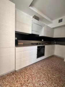 a kitchen with white cabinets and a stove top oven at Le Piazzette 2 in Schio