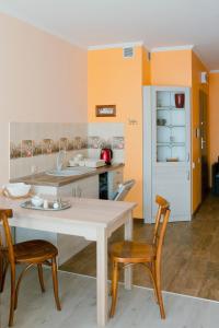 a kitchen with a white table and two chairs at Apartament Polonia in Ełk