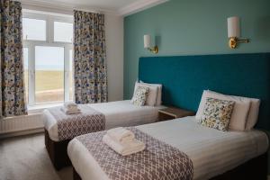 a hotel room with two beds and a window at The Kilbirnie Hotel in Newquay +75 photos