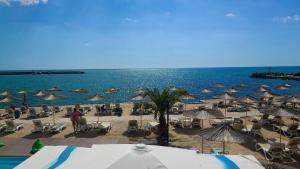 a beach with chairs and umbrellas and the ocean at Royal Grand Hotel and Spa - All Inclusive and Free beach accsess in Kavarna