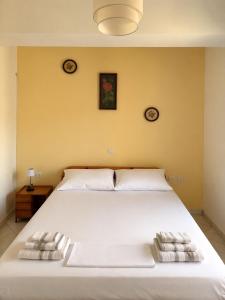 a bedroom with a large white bed with two pillows at Pelekanos Apartment in Paralia Saranti