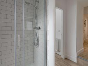 a bathroom with a shower with white tiled walls at 3 Bed in Crieff oc-90794 in Comrie +9 photos