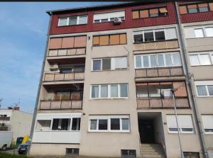 a tall apartment building with a red roof at Studio Apartman Tara in Daruvar
