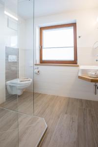 ein Badezimmer mit Toilette und Glasdusche in der Unterkunft Hotel Kasimir in Riezlern + 56 Fotos