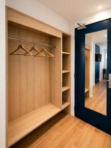 a walk in closet with wooden shelves and a mirror at The Originals City, Hôtel Mâcon Sud in Chaintré +71 photos
