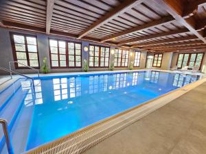a large indoor swimming pool with blue water at Bergresort Gerlitzen in Treffen