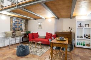 a living room with a red couch and a table at Albavilla Stone Loft in Albavilla