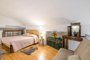 a bedroom with a bed and a desk and a couch at Albavilla Stone Loft in Albavilla