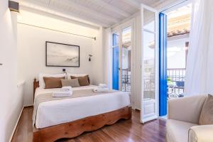 a bedroom with a large bed and a balcony at The Blue Door - Skopelos in Skopelos Town