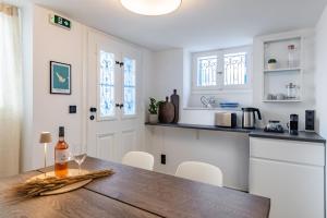 a kitchen with a wooden table with a bottle of wine at The Blue Door - Skopelos in Skopelos Town