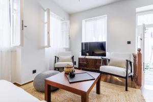 a living room with a tv and a coffee table at The Blue Door - Skopelos in Skopelos Town