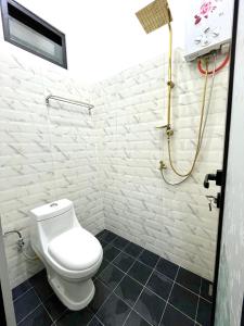 a white bathroom with a toilet and a shower at Lovia Villa Dieng in Kejajar +22 photos