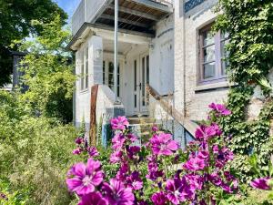 an old house with purple flowers in front of it at Deichliebe 290 Ökologisches Ferienhaus Stöckte in Winsen