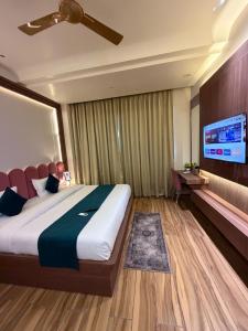 a hotel room with a bed and a tv at The Infinity Hotel in Kānpur