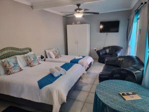 a room with two beds and a couch and a table at Boskraai Self-Catering -74 Hornbill Street in St Lucia +37 photos