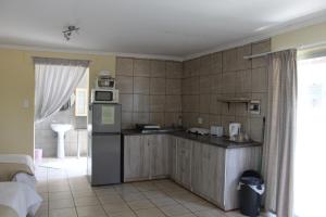 a kitchen with a refrigerator and a counter top at Ruacana Guest House in Ruacana