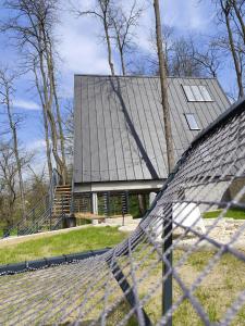 a house with a metal roof with a fence at PiatrA Frame in Ştefeşti