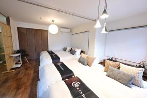 a hotel room with three beds in it at EN Matsubara in Kagoshima