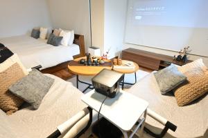 a room with two beds and a projection screen at EN Matsubara in Kagoshima +21 photos