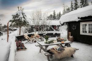 a patio covered in snow with a table and chairs at TH622- Premium ski-in,out Chalet with 8 bedroom, jacuzzi, sauna in Hovi