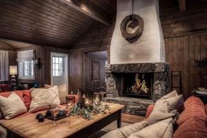 a living room with a couch and a fireplace at TH622- Premium ski-in,out Chalet with 8 bedroom, jacuzzi, sauna in Hovi +79 photos