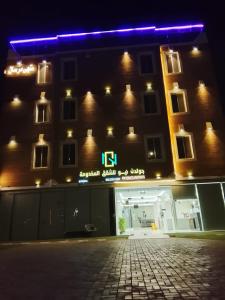a building with a blue light on the side of it at Golden New Muhayil-نيلولوفر فور in Ḑirs