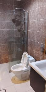 a bathroom with a toilet and a shower and a sink at Golden New Muhayil-نيلولوفر فور in Ḑirs +3 photos