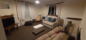 a living room with a couch and a television at Brookside Lodge, central Dawlish in Dawlish