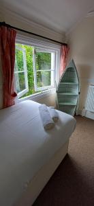a bedroom with a large bed and a window at Brookside Lodge, central Dawlish in Dawlish