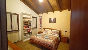 a bedroom with a bed and a book shelf at Castellato Country House in Pietra de' Giorgi +27 photos
