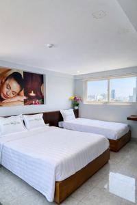 two beds in a hotel room with a large window at Hồng Phúc 7 Hotel in Danang