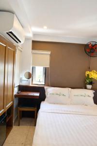 a bedroom with a bed and a desk with a window at Hồng Phúc 7 Hotel in Danang