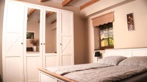 a bedroom with a white cabinet and a bed at Ekofarma Selwit in Sosnówka