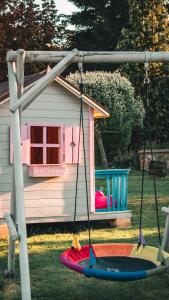 a swing in front of a play house at Ekofarma Selwit in Sosnówka