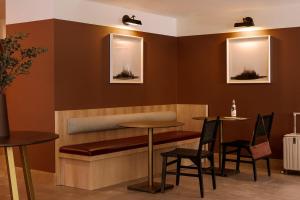 a restaurant with a bench and two tables and chairs at Roami at The Fitz in Saint Paul