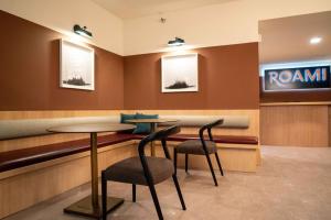 a restaurant with two tables and chairs and a sign at Roami at The Fitz in Saint Paul
