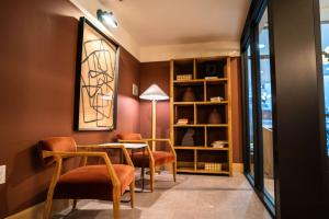 a dining room with orange chairs and a table at Roami at The Fitz in Saint Paul +26 photos