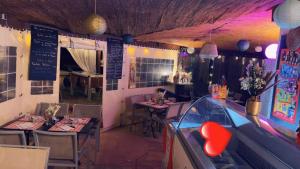 a restaurant with tables and chairs and a game at Camping de la Chapelette in Saint-Martin-de-Crau