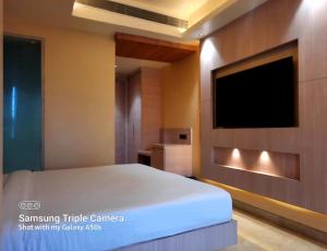 a bedroom with a bed and a flat screen tv at THE GRAND SUNCITY HOTEL AND RESORT, Bhopal in Bhopal