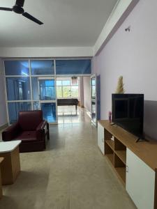 a living room with a couch and a television at Silo namlo 2BHK in Duimukh