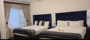 a bedroom with two beds and a window at Ayjalon Guest Home in Ludeke +8 photos
