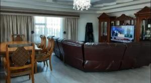 a living room with a large leather couch and a table at Ayjalon Guest Home in Ludeke
