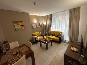 a living room with a couch and a table at Edelweiss Mountain Apartment - Stream Resort Spa & Pool, Pamporovo in Pamporovo